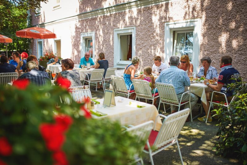 Gäste genießen das schöne Wetter im Gastgarten des Landgasthof Bachlerhofs in Kematen an der Ybbs (Niederösterreich)
